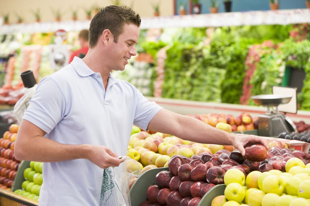 um homem escolhe frutas para aumentar a potência